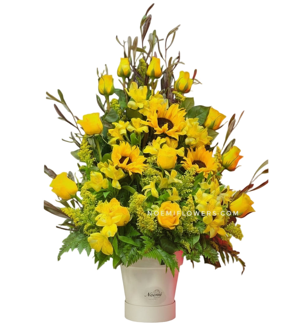 Arreglo floral confeccionado con 12 rosas amarillas, girasoles y astromelias con follaje variado.- Floristería Noemi Flowers