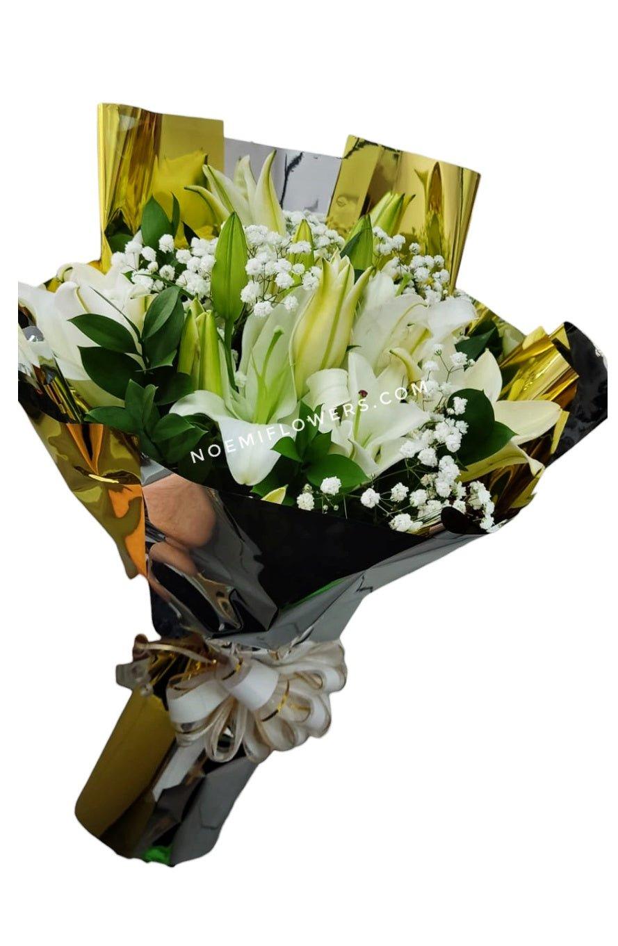 Ramo de Lirios con follaje envuelto en papel decorativo y lazo - Floristería Noemi Flowers