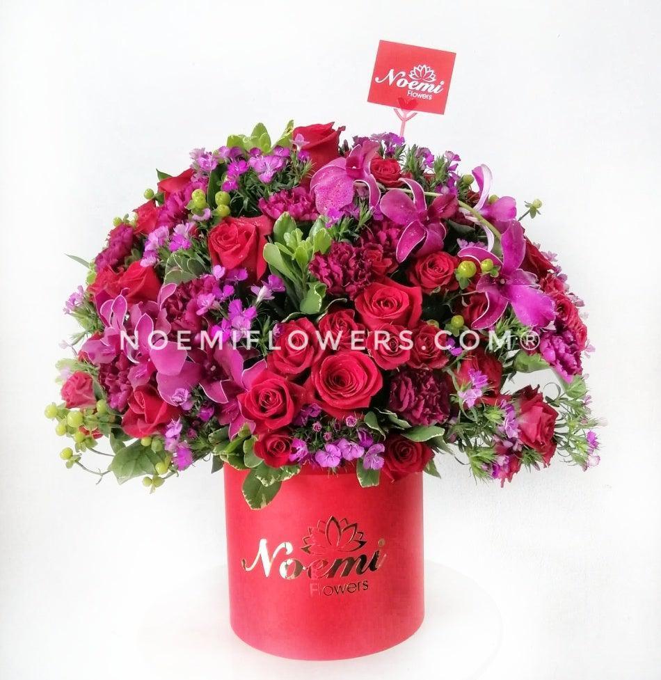 Caja de Rosas rojas claveles orquideas follaje- Floristería Noemi Flowers