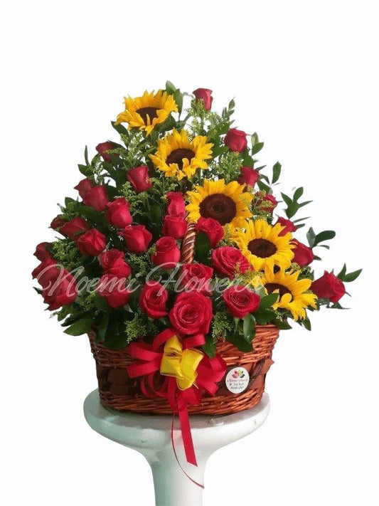 Dueña de mi corazón confeccionado con rosas, girasoles, solidago y follaje variado en canasta de mimbre - Floristería Noemi Flowers