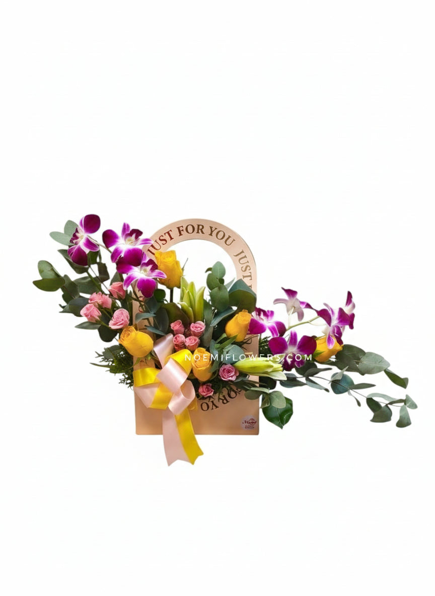 Arreglo floral compuesto por exquisitas orquídeas, lirios, rosas y mini rosas acompañado por delicado follaje variado- Floristería Noemi Flowers.