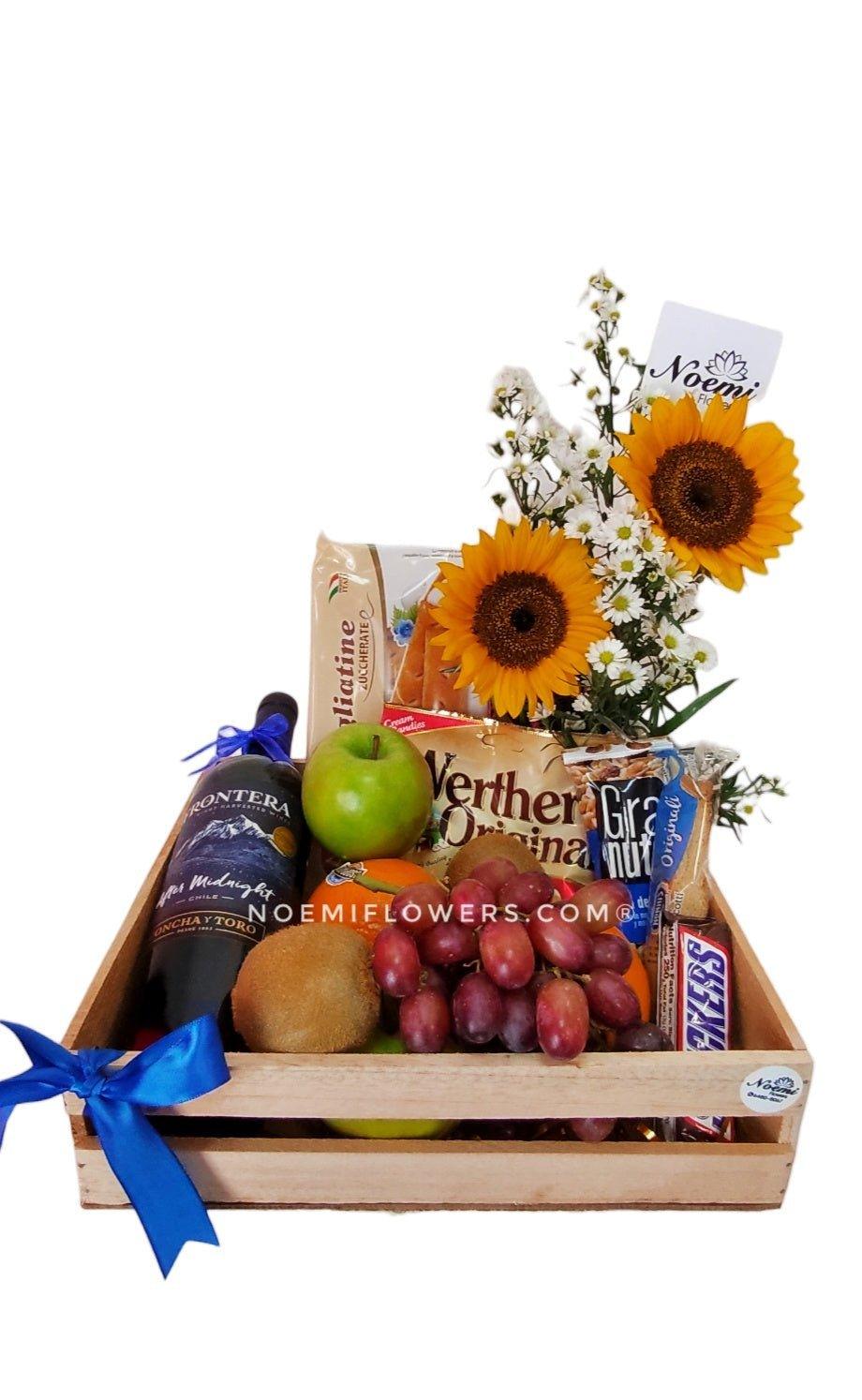 Regalo con frutas vino snacks y girasoles - Floristería Noemi Flowers