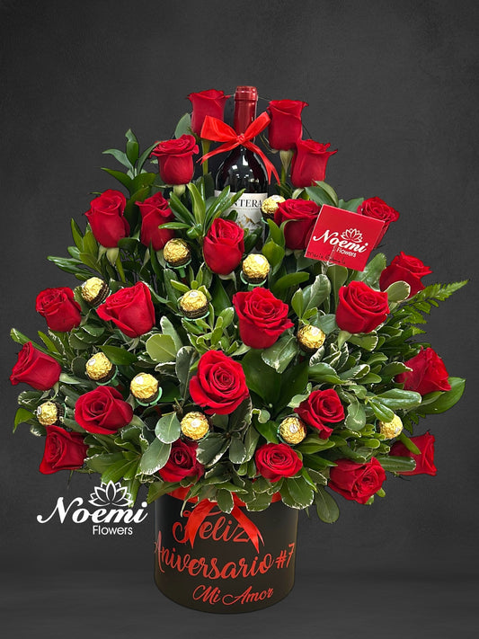 Caja de rosas rojas con bombones de chocolates y botella de vino tinto - Floristería Noemi Flowers 