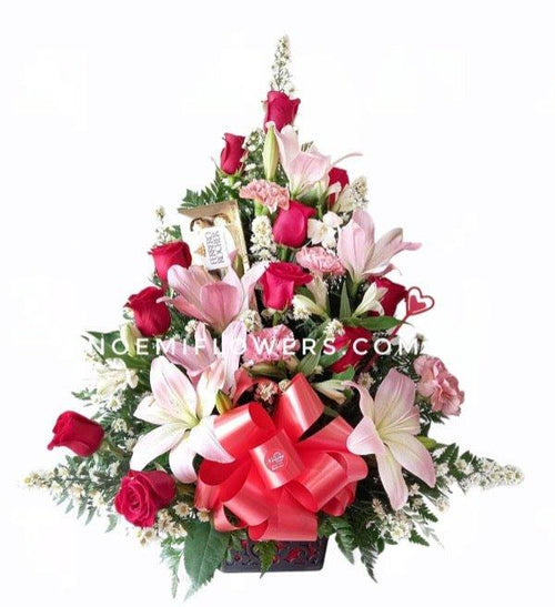 Arreglo floral elegante que combina rosas rojas, lirios, claveles y astromelias con follaje fresco. Incluye una caja de Ferrero Rocher de 8 unidades - Floristería Noemi Flowers