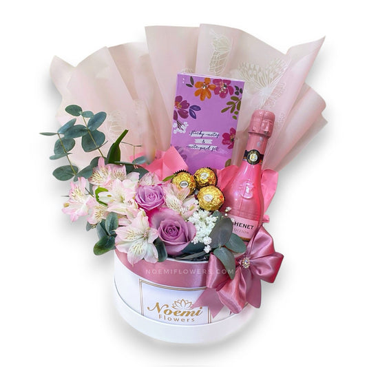 Caja confeccionada con rosas, astromelias, gipsofilia y bombones Ferrero Rocher, vino espumoso JP Chenet - Floristería Noemi Flowers. 