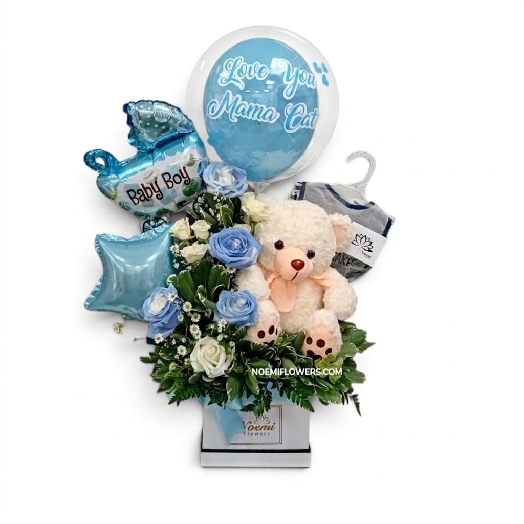 Arreglo floral de nacimiento confeccionado con 1 peluche, 1 regalo para el bebé, 2 globos de 9", 1 globo burbuja personalizado con globo latex dentro, rosas tinturadas en azul, mini rosas y follaje variado - Floristería Noemi Flowers. 