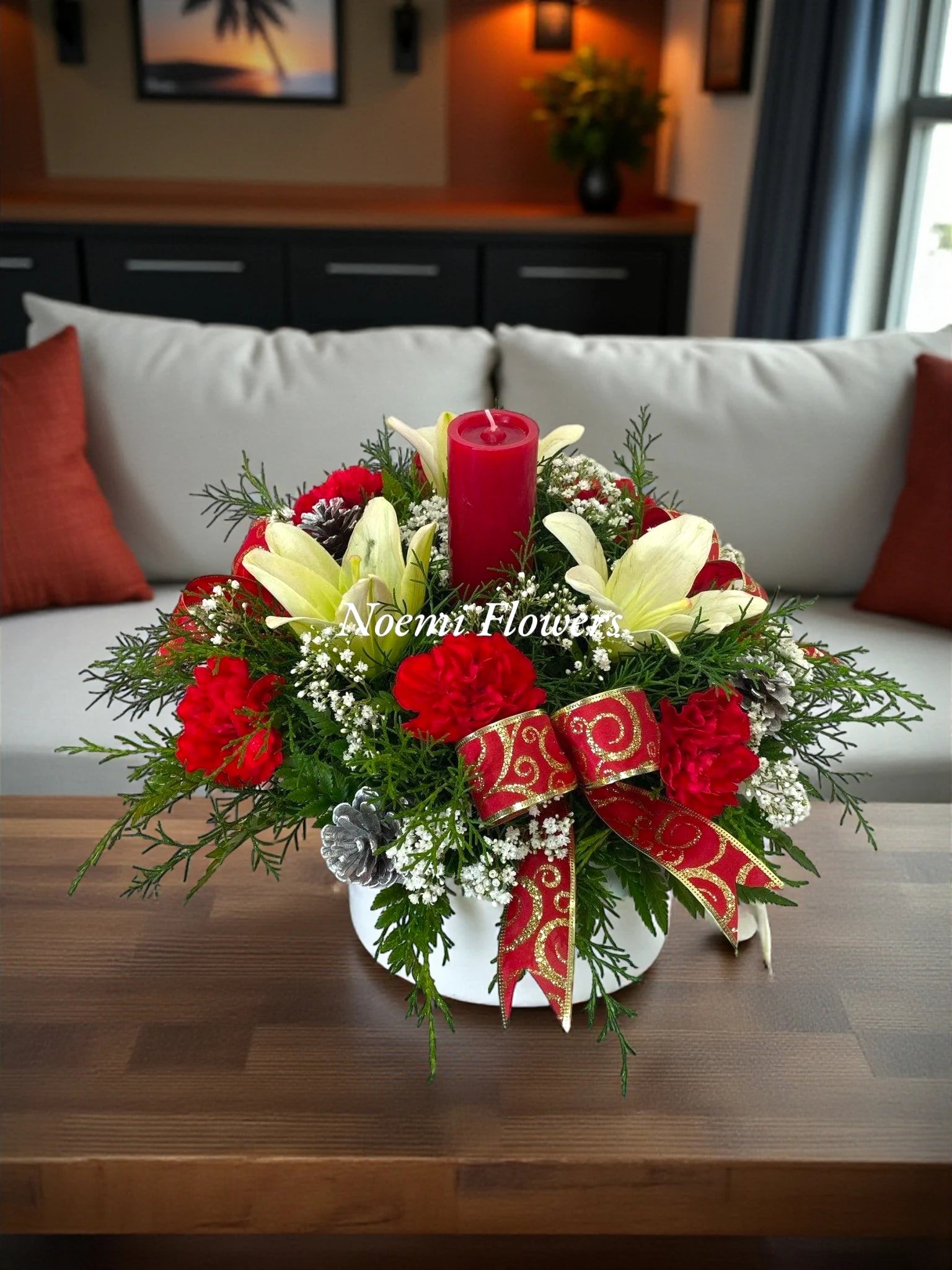 Centro de mesa navideño con claveles rojos, lirios, pino y 1 vela