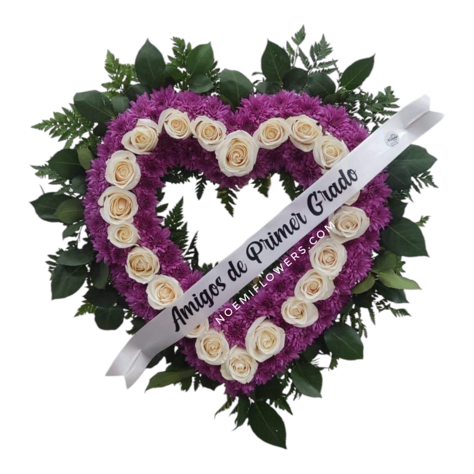 Corona NF - 12 Corona en forma de corazón con rosas blancas y deisys lila. Follaje puede variar según disponibilidad o temporada. Mide 22 pulgadas de diámetro.- Floristería Noemi Flowers