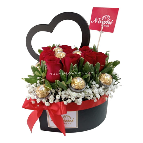 Arreglo confeccionado con caja con forma de corazón con rosas y deliciosos bombones Ferreros Rocher y follaje variado - Floristería Noemi Flowers. 