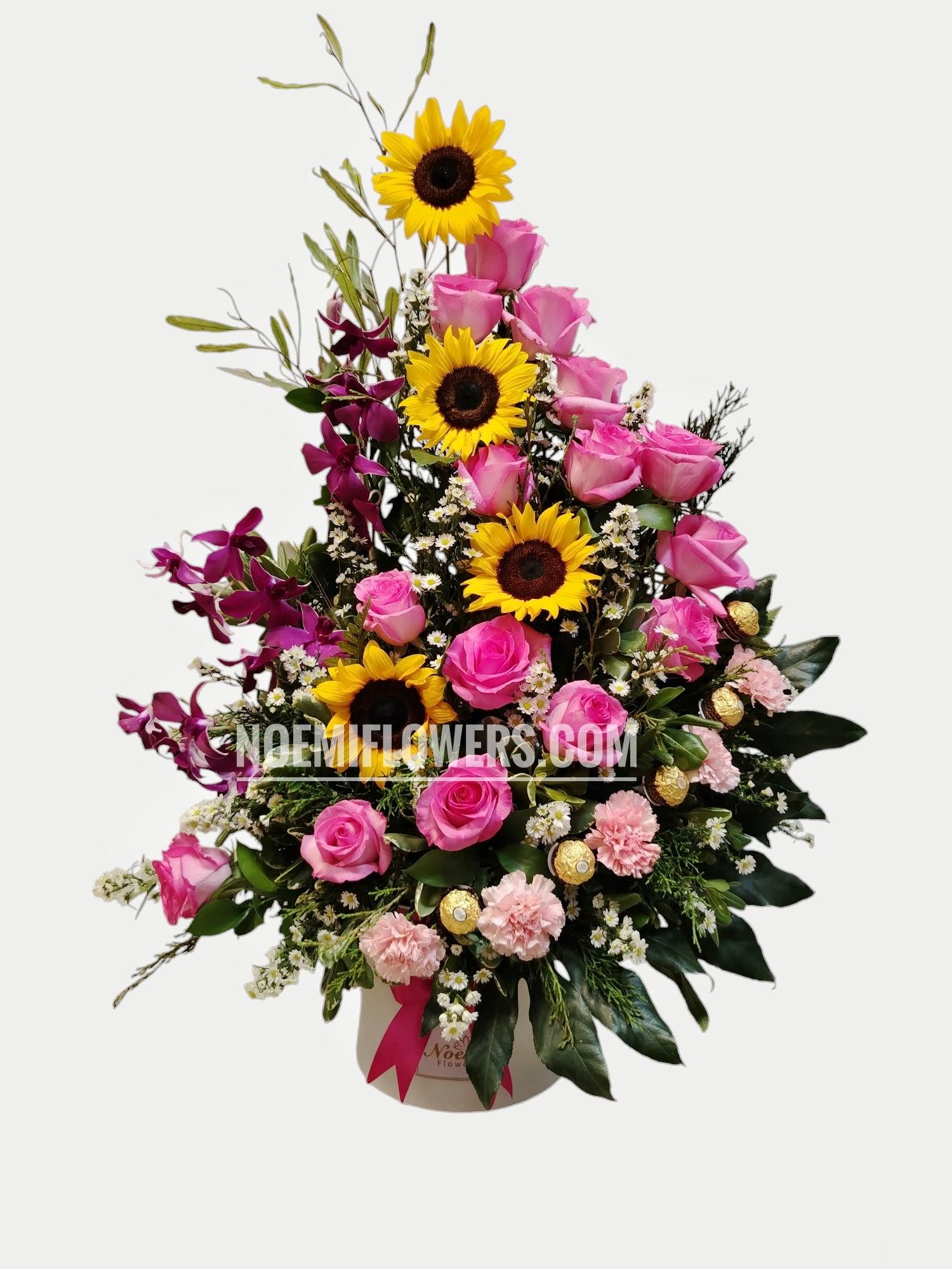 Libélula confeccionada con rosas, girasoles, orquídeas, Deliciosos bombones Ferrero Rocher y follaje variado - Floristería Noemi Flowers