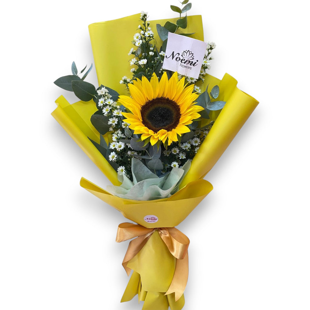 Girasol, astromelias y un toque de eucalipto en papel decorativo - Floristería Noemi Flowers