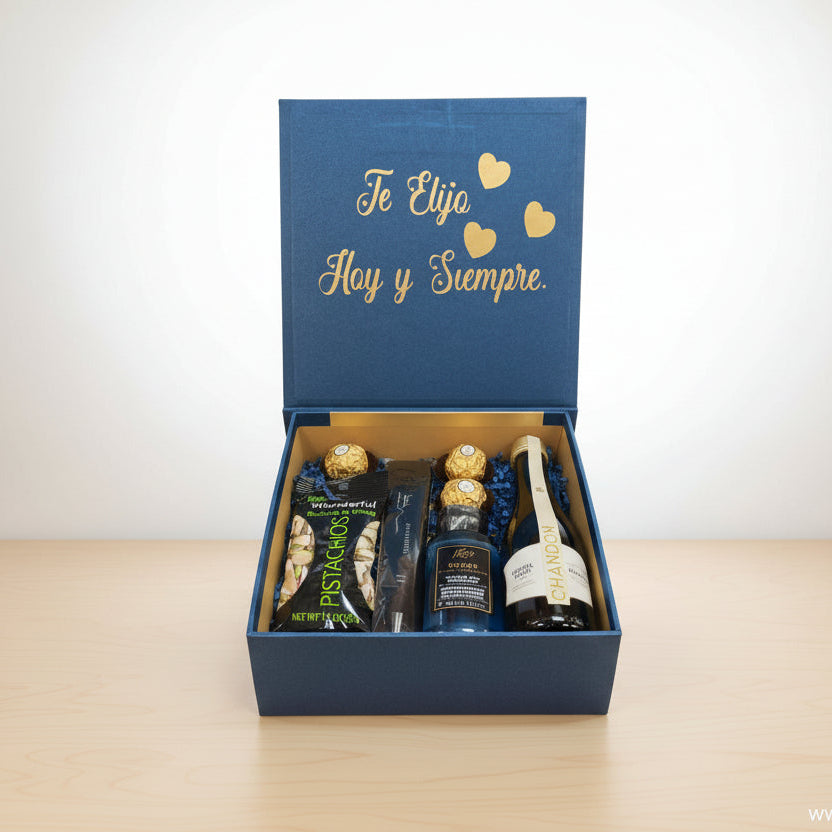 Compuesta: 1 Snacks, 3 Bombones Ferrero Rocher,1 Botella de vino espumoso,1 Bolígrafo,1 Gel de baño, 1 frase corta personalizada - Floristería Noemi Flowers.