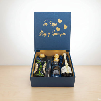 Compuesta: 1 Snacks, 3 Bombones Ferrero Rocher,1 Botella de vino espumoso,1 Bolígrafo,1 Gel de baño, 1 frase corta personalizada - Floristería Noemi Flowers.