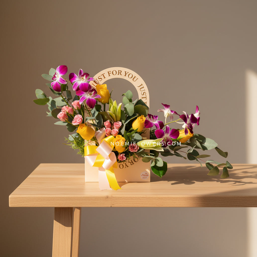 Arreglo floral compuesto por exquisitas orquídeas, lirios, rosas y mini rosas acompañado por delicado follaje variado- Floristería Noemi Flowers. 