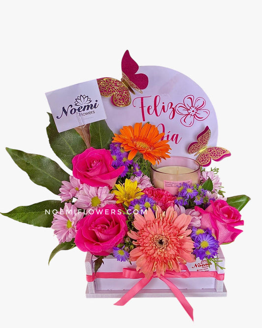 Arreglo floral con gerberas, rosas y claveles, vela aromática - Floristería Noemi Flowers.
