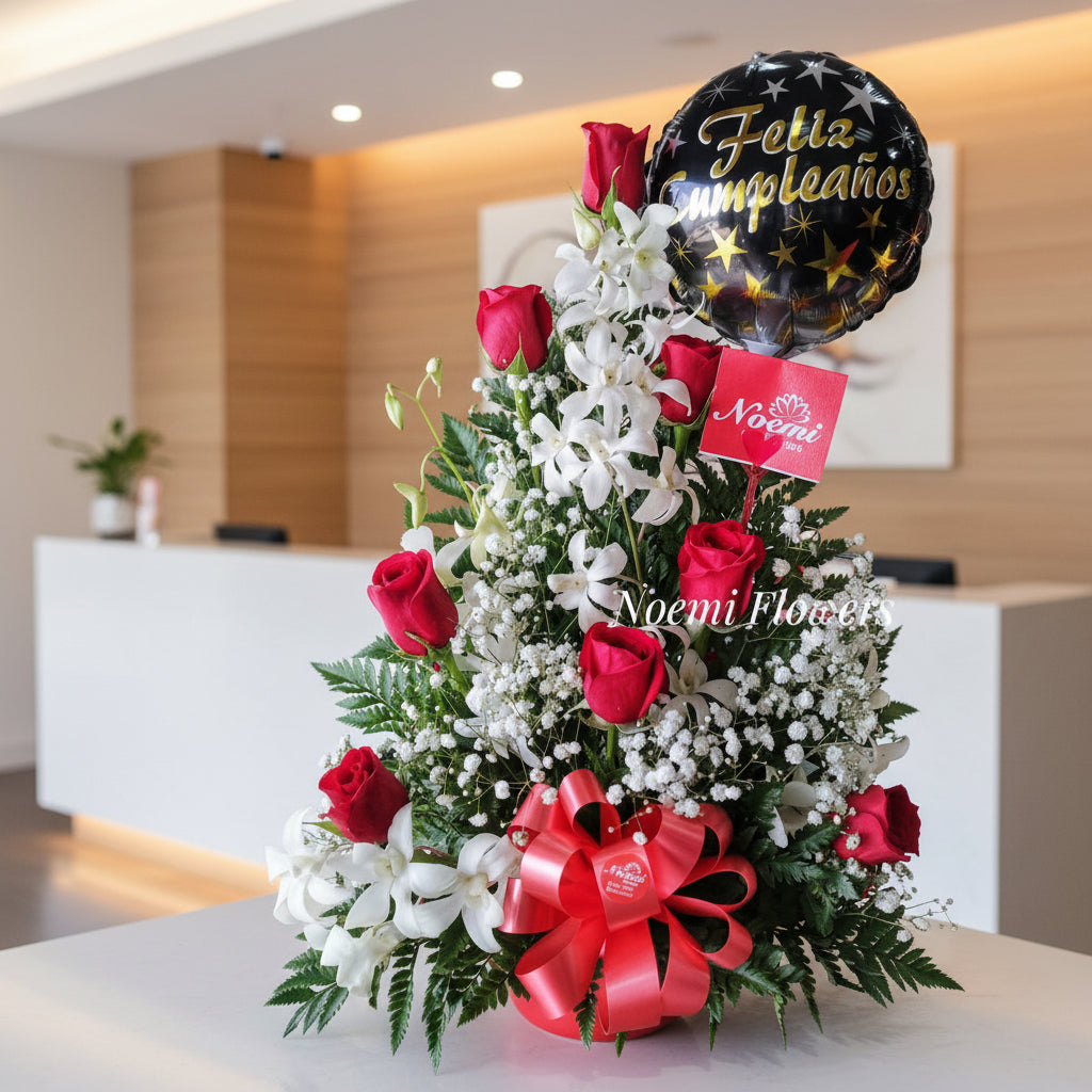 Arreglo floral es elaborado con orquídeas elegantes y hermosas rosas adornadas con follaje variado según disponibilidad. Incluye un globo de 9"Floristería Noemi Flowers