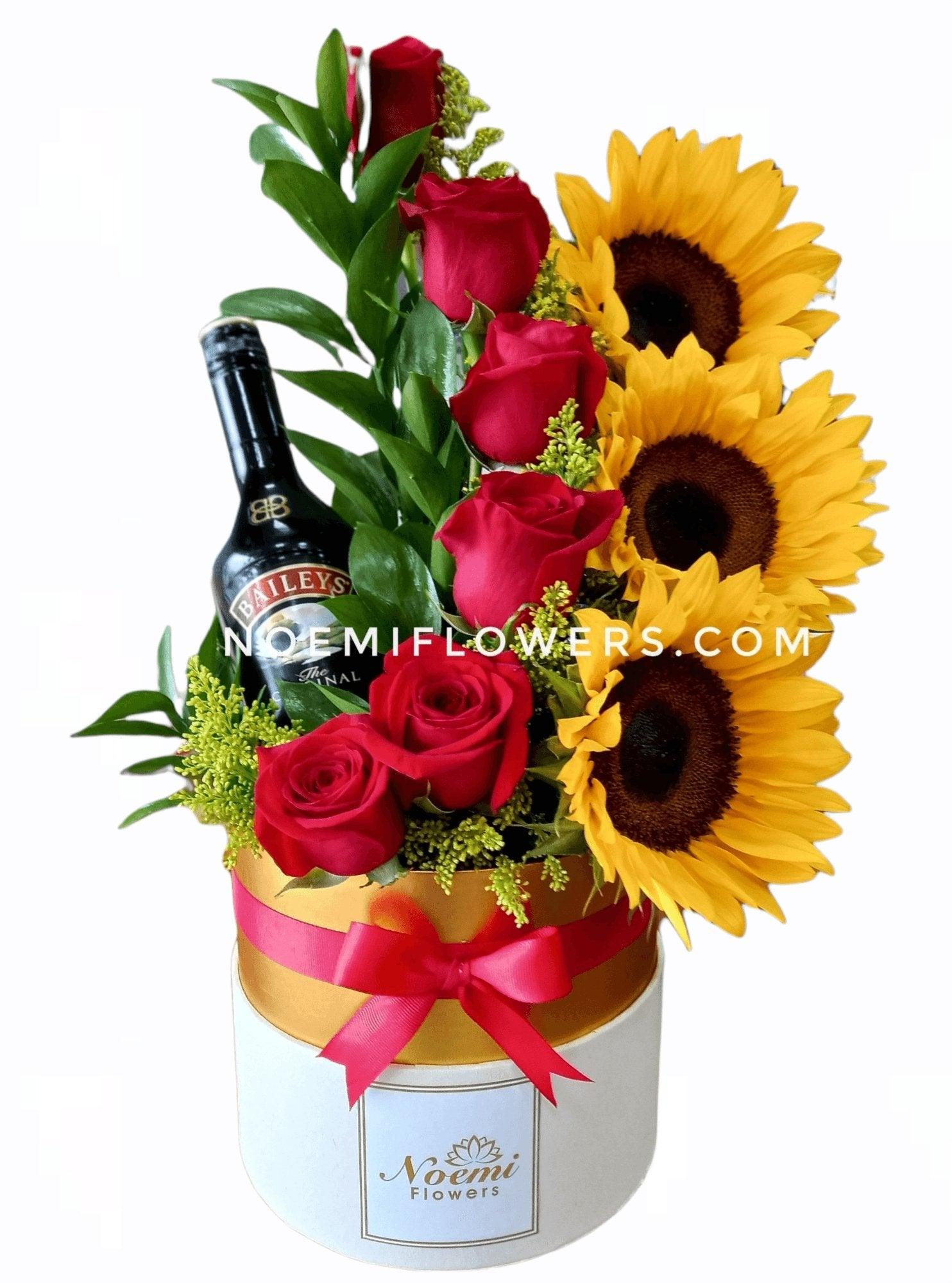 Caja con rosas y girasoles además de botella de Baileys- Floristería Noemi Flowers