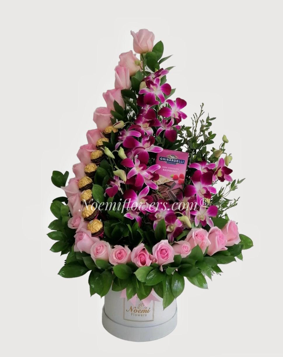 Corazón Cautivo confeccionado con rosas, orquídeas, deliciosos bombones Ferrero Rocher y follaje variado - Floristería Noemi Flowers