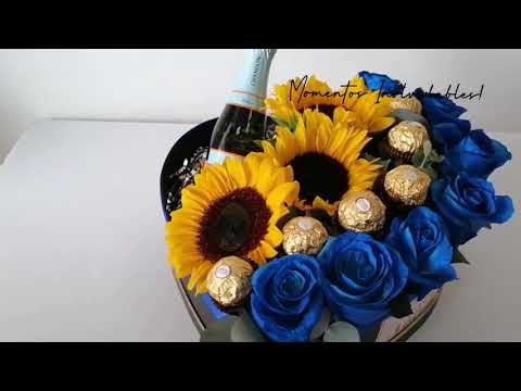 Rosas tinturadas en azul y girasoles en elegante caja con forma de corazón a elegir en colores negro o blanco:  Mini botella Chandon Bombones de chocolates Ferrero Rocher Un regalo que le encantará! 